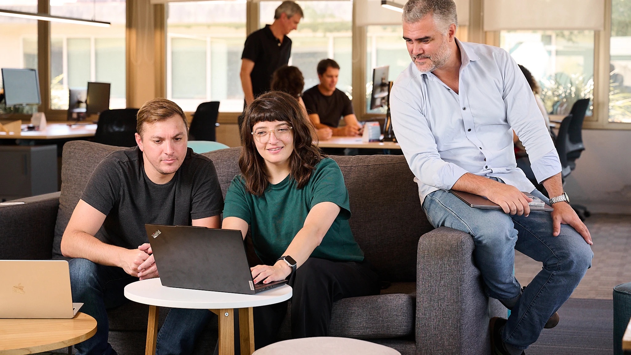 Cloudgaia colleagues working together around a laptop in an office