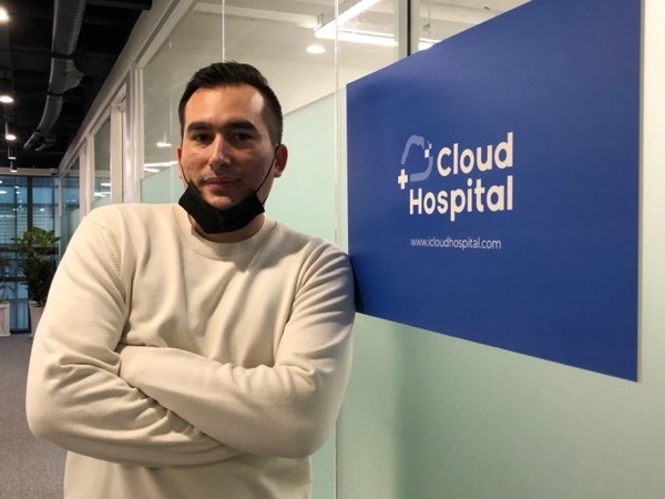 CloudHospital founder Suleyman Nazarov standing beside the company's office sign