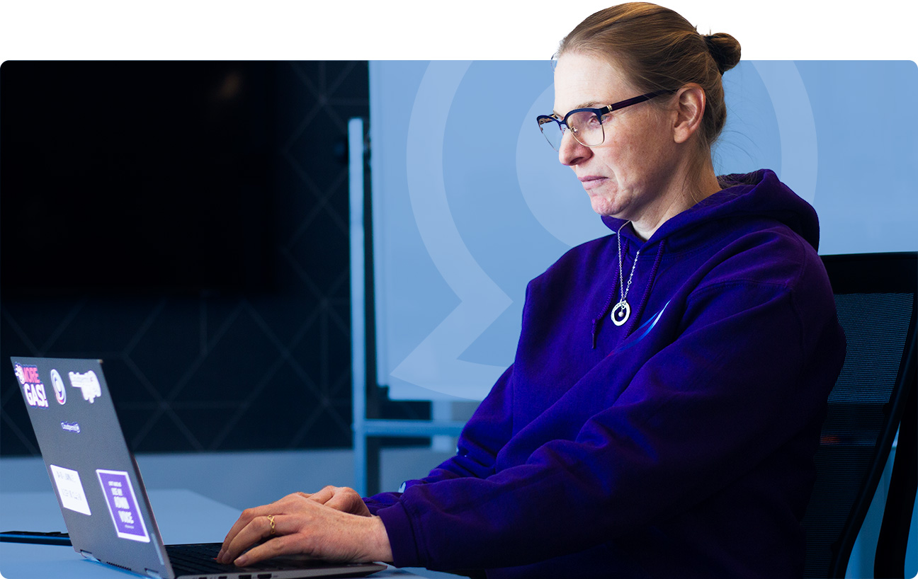 A Cloudpermit team member working at a laptop in the company's office