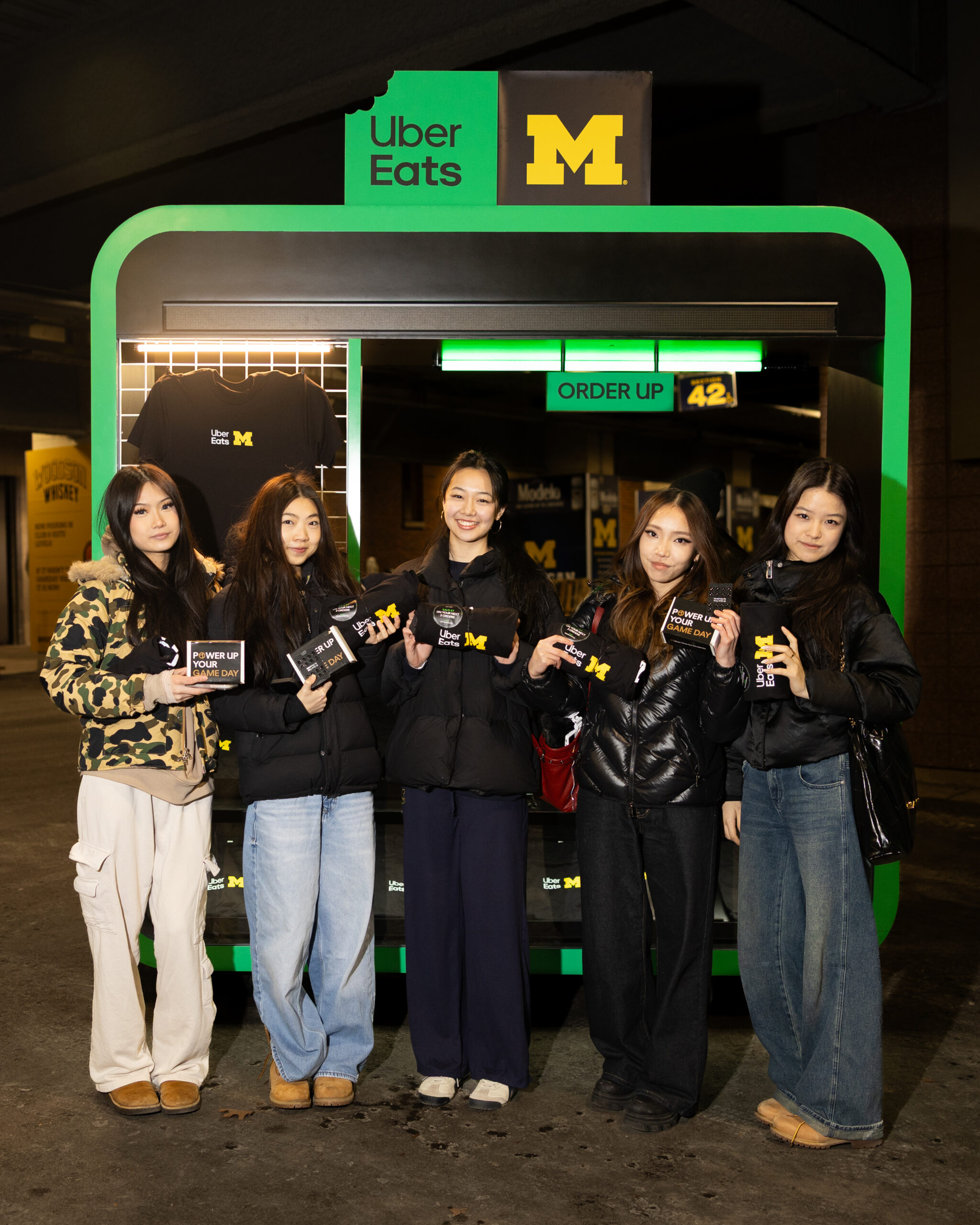 Students holding merchandise at an Uber Eats campus activation produced by CNC Agency