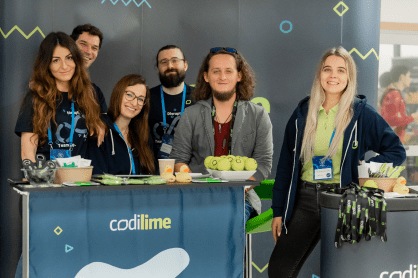 Five CodiLime team members behind a company booth at an event