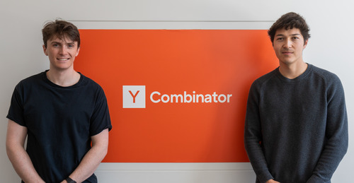 John Newsom and Cody Swain standing on either side of a Y Combinator sign