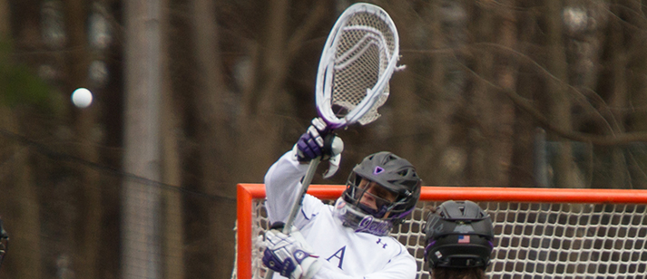 Cody Tranbarger raises his goalkeeper’s stick beside the Amherst lacrosse goal
