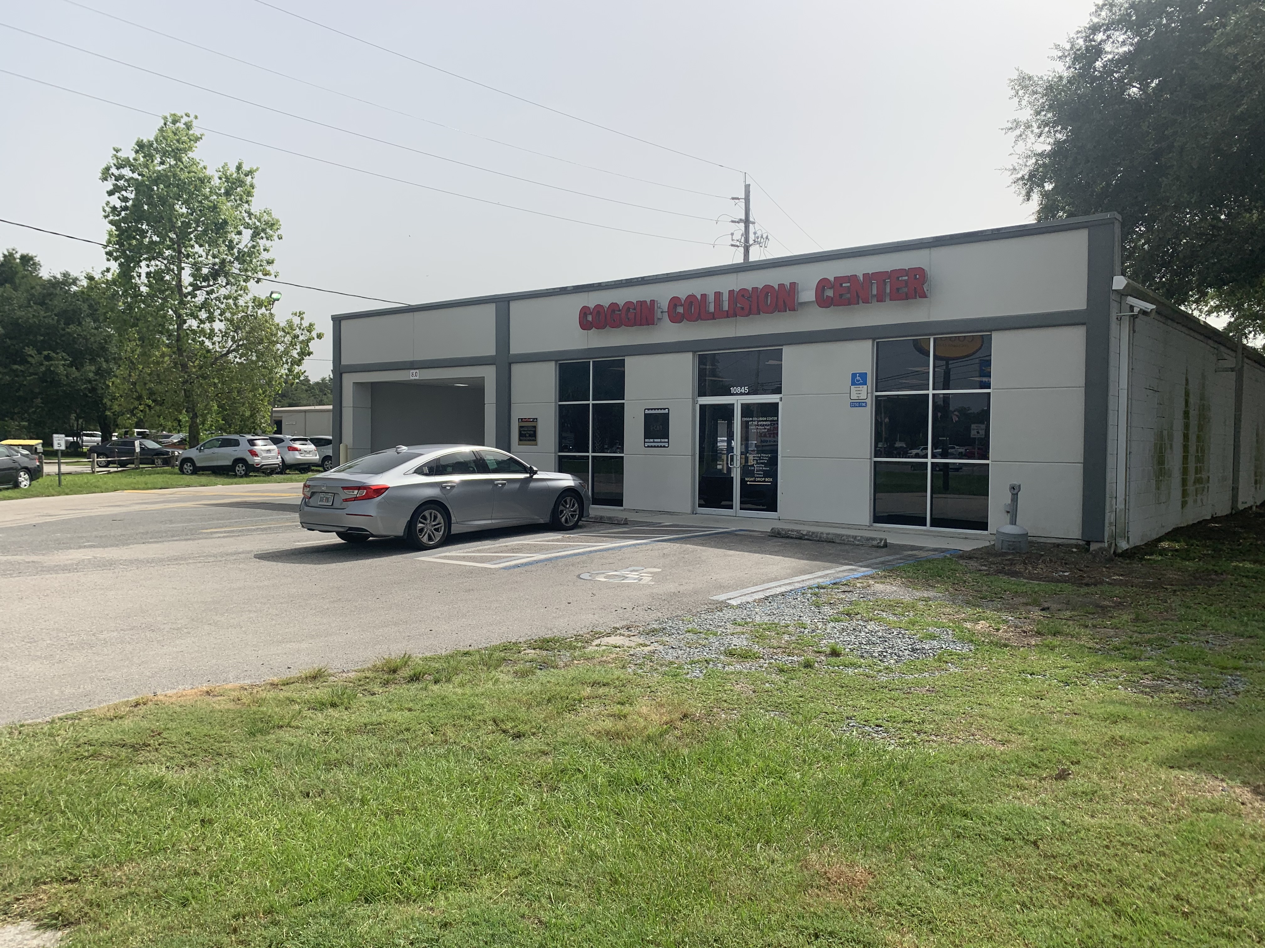 Coggin Collision Center at the Avenues, with a car parked outside its service entrance