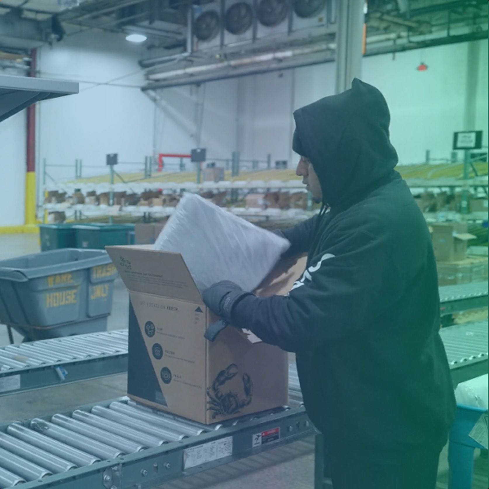 A ColdTrack warehouse associate fits an insulating liner into a Fulton Fish Market shipping box