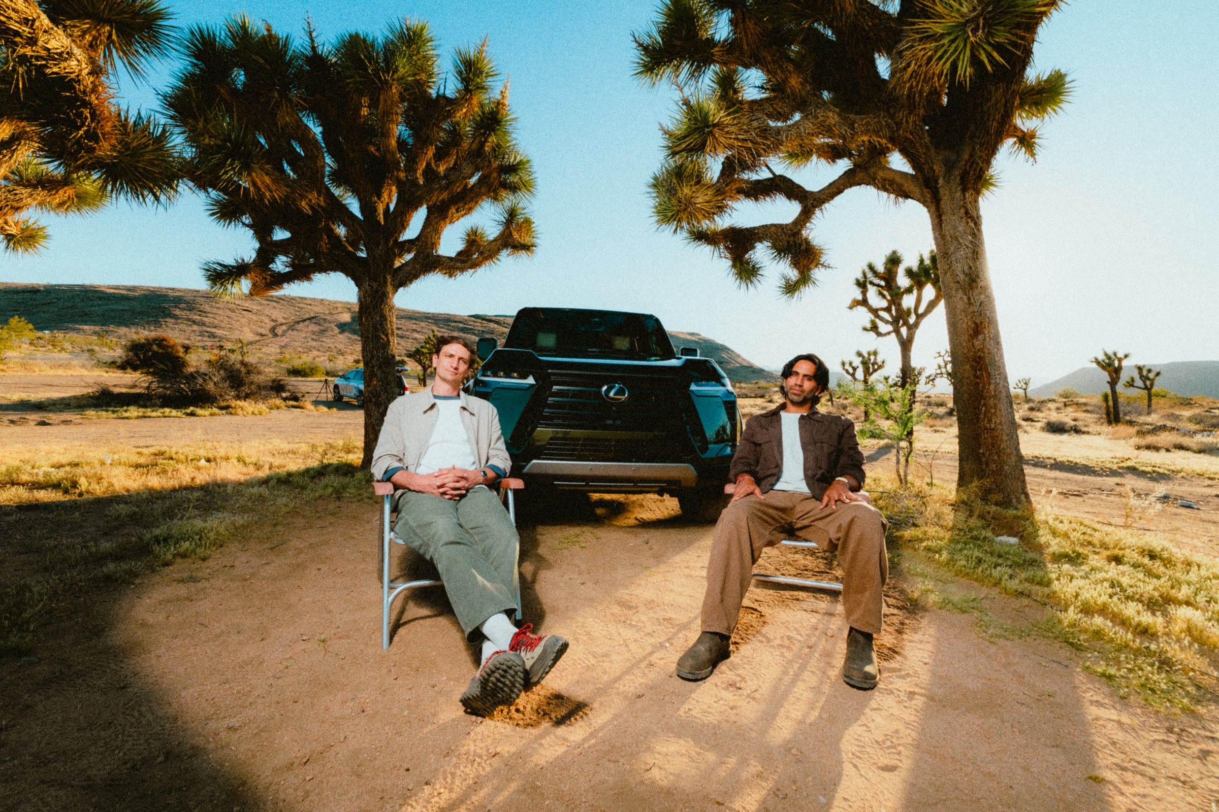 Colin and Samir seated in the Joshua Tree desert beside a vehicle for their Start Over series