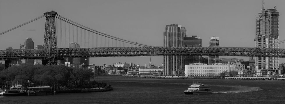 Black-and-white photograph of the Williamsburg Bridge and New York waterfront, taken by Colin Barnhart