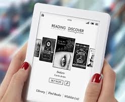 A hand holding a Kobo e-reader displaying a digital bookstore