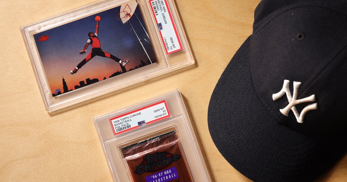 PSA-encapsulated Michael Jordan card and basketball foil pack beside a Yankees cap