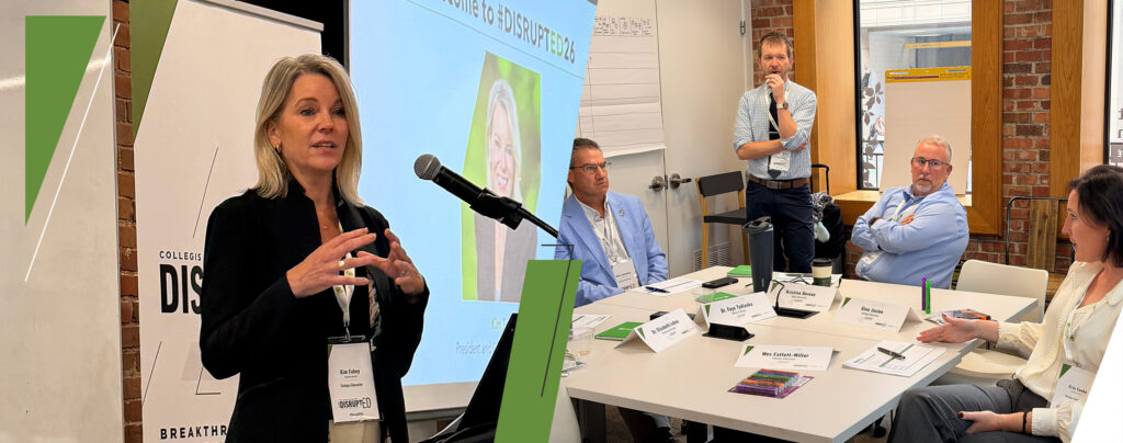 Kim Fahey speaking at DisruptED26 beside a roundtable discussion among higher education leaders