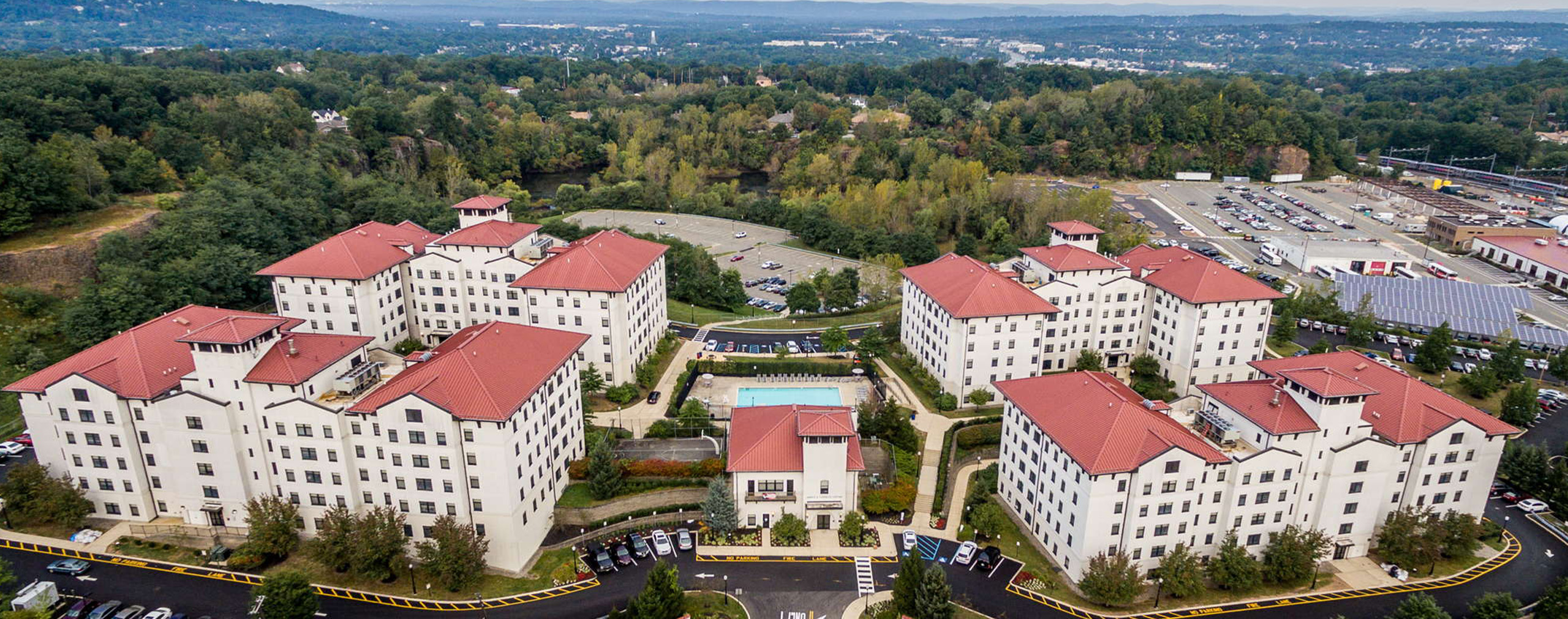 Aerial view of Montclair State University buildings with red roofs and surrounding trees