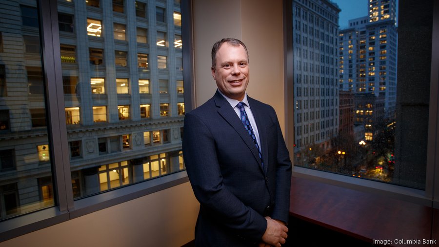 Clint Stein standing in an office before windows overlooking the city