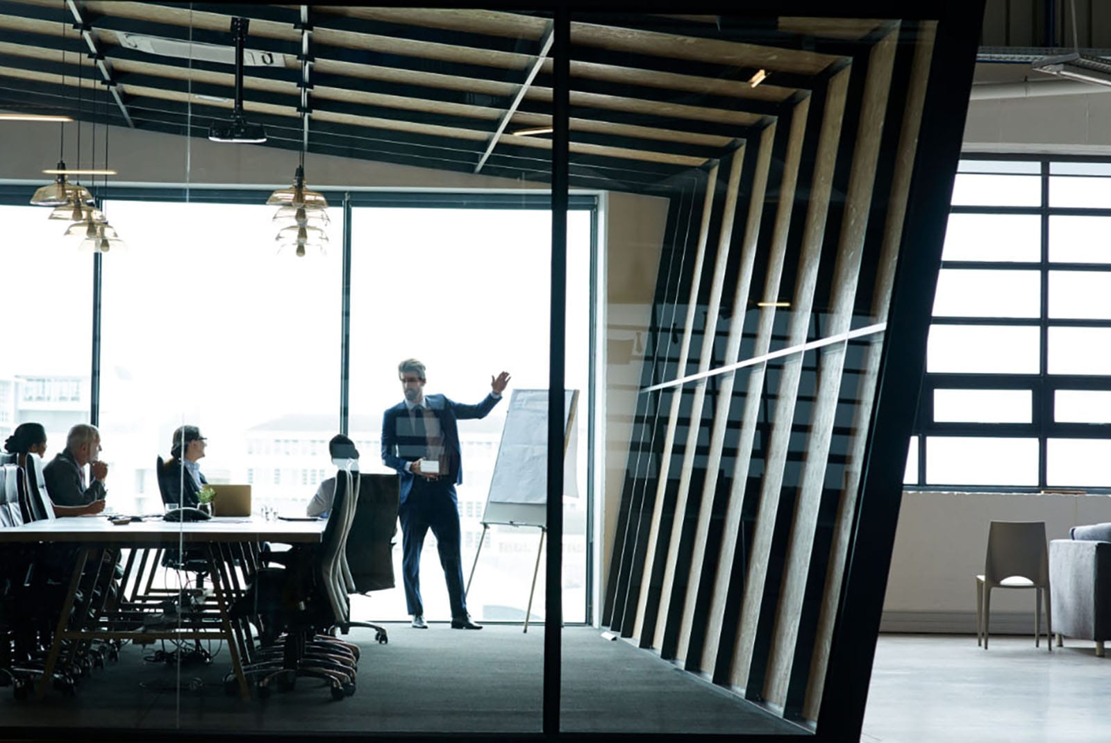 A meeting underway in a glass-walled conference room