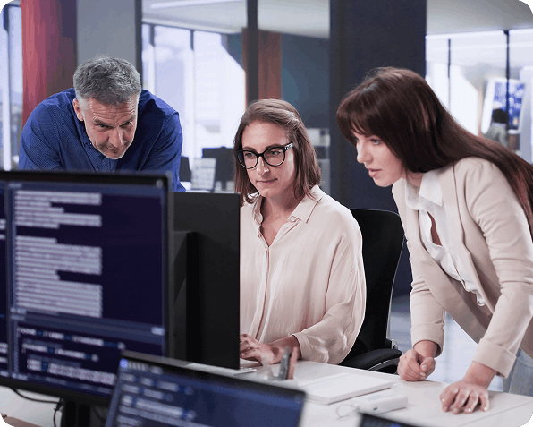 Three people reviewing software on a computer in official Comtrade 360 engineering imagery