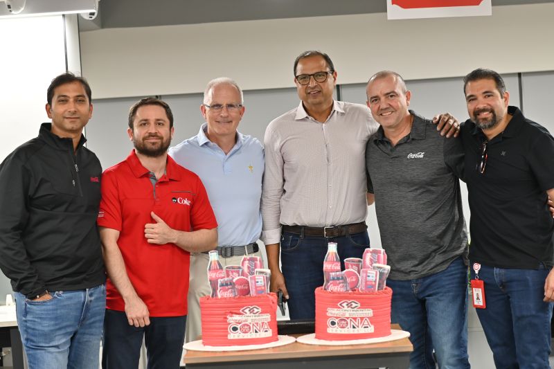 CONA, Coca-Cola Southwest Beverages and CoreFlex colleagues gathered behind two Coca-Cola and CONA themed cakes in Bengaluru