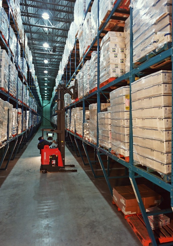 Archive photograph of a forklift between tall racks of boxed products