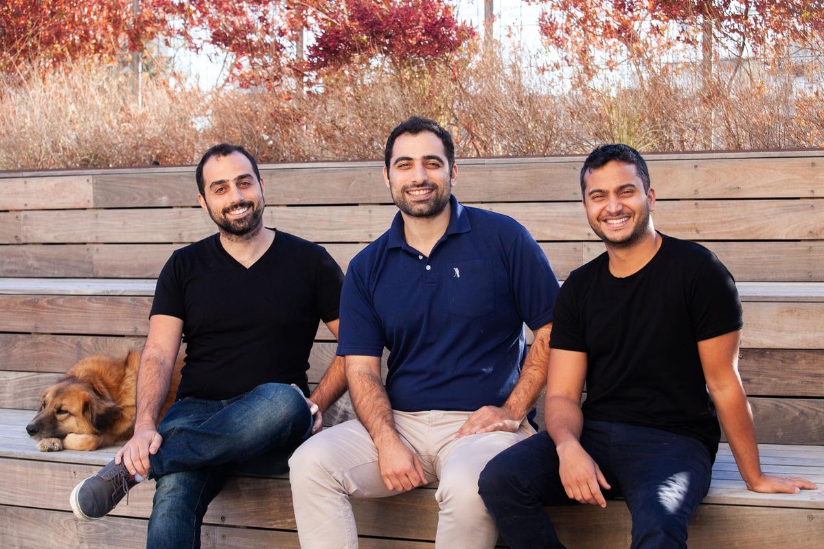 Connecteam co-founders Daniel Nuriel, Amir Nehemia and Yonatan Nuriel sitting outdoors with a dog