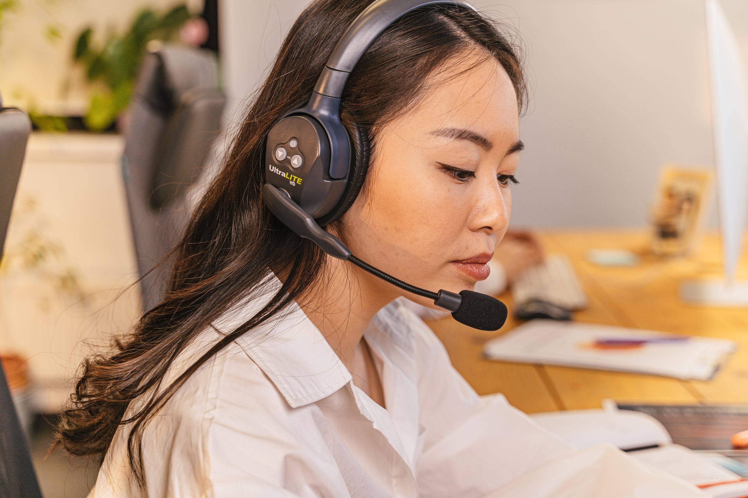 Customer service agent wearing a headset at a computer