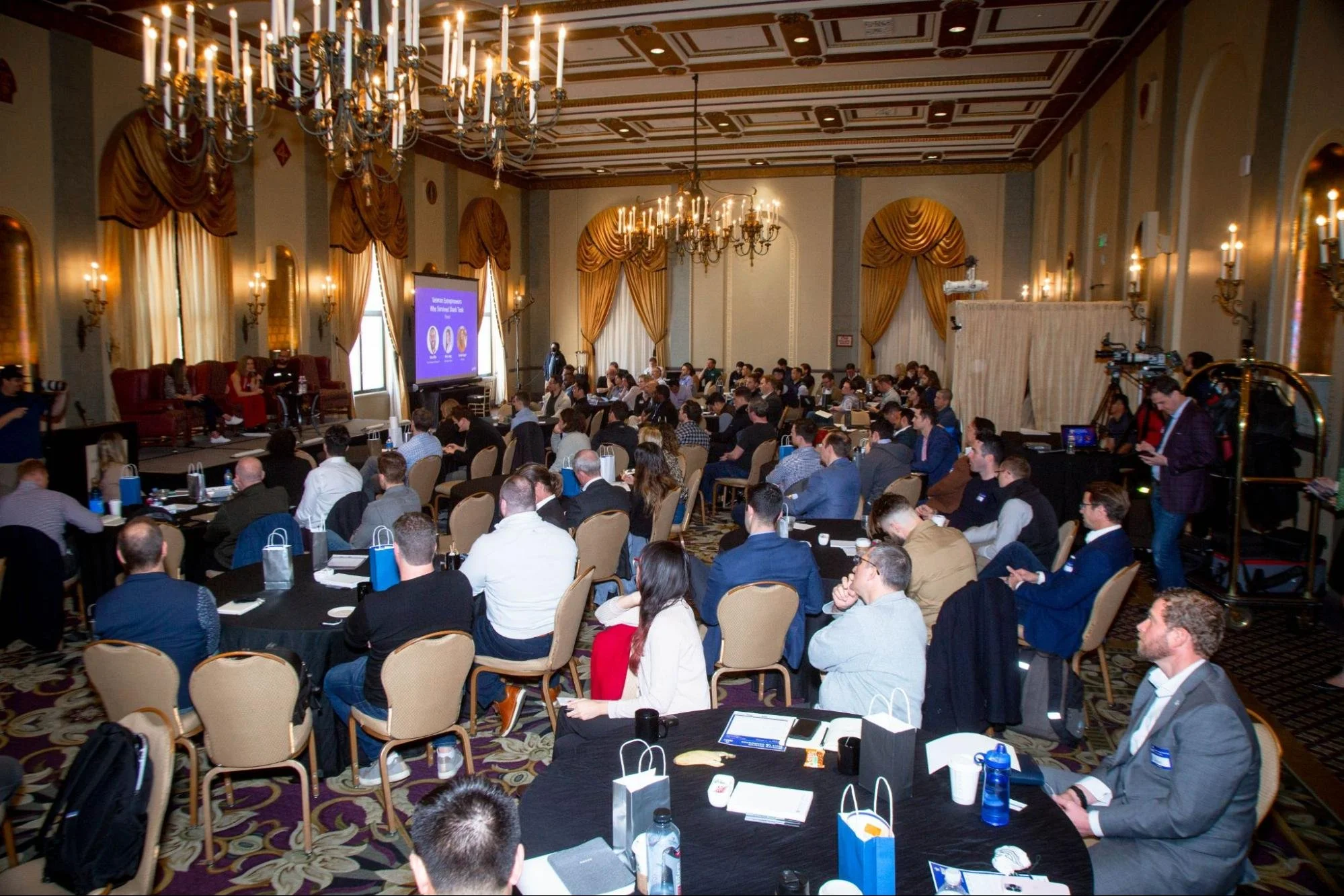 Founders and investors seated at round tables during a military veteran startup conference