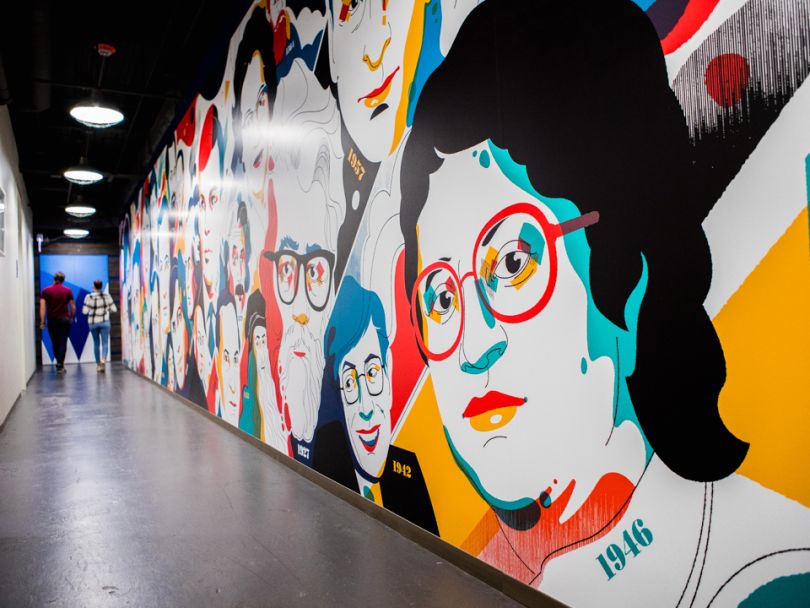 A colorful portrait mural along a corridor at Conversant’s Chicago office