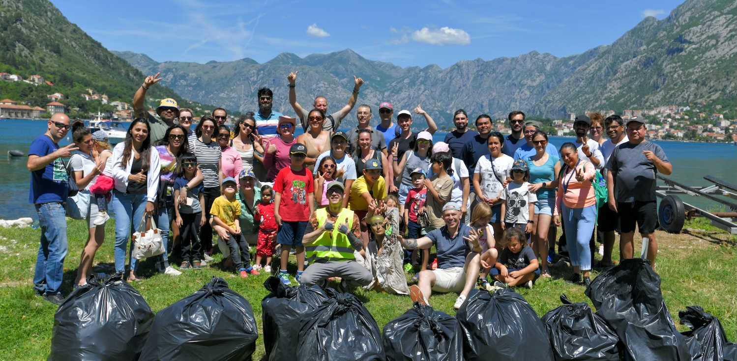 Convert.com team members cleaning a beach at Kotor Bay