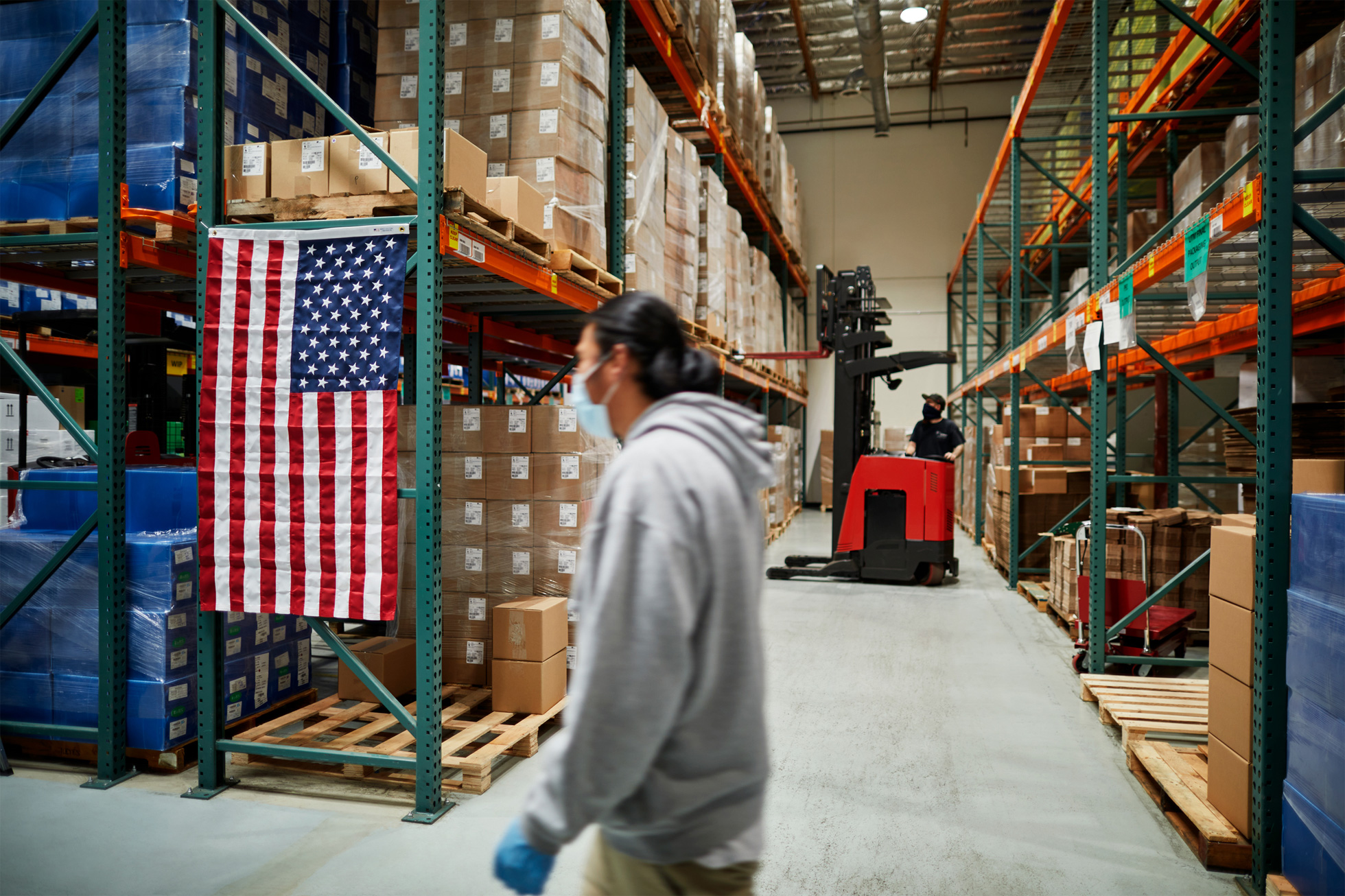 Workers handling supplies inside a COPAN Diagnostics manufacturing facility during the pandemic expansion