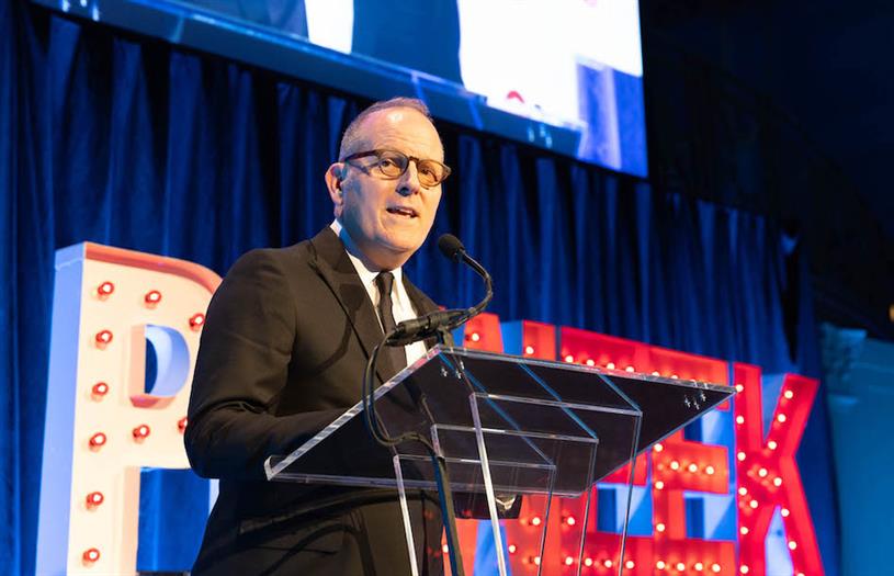 Corey duBrowa speaking from a clear lectern at the 2023 PRWeek Awards