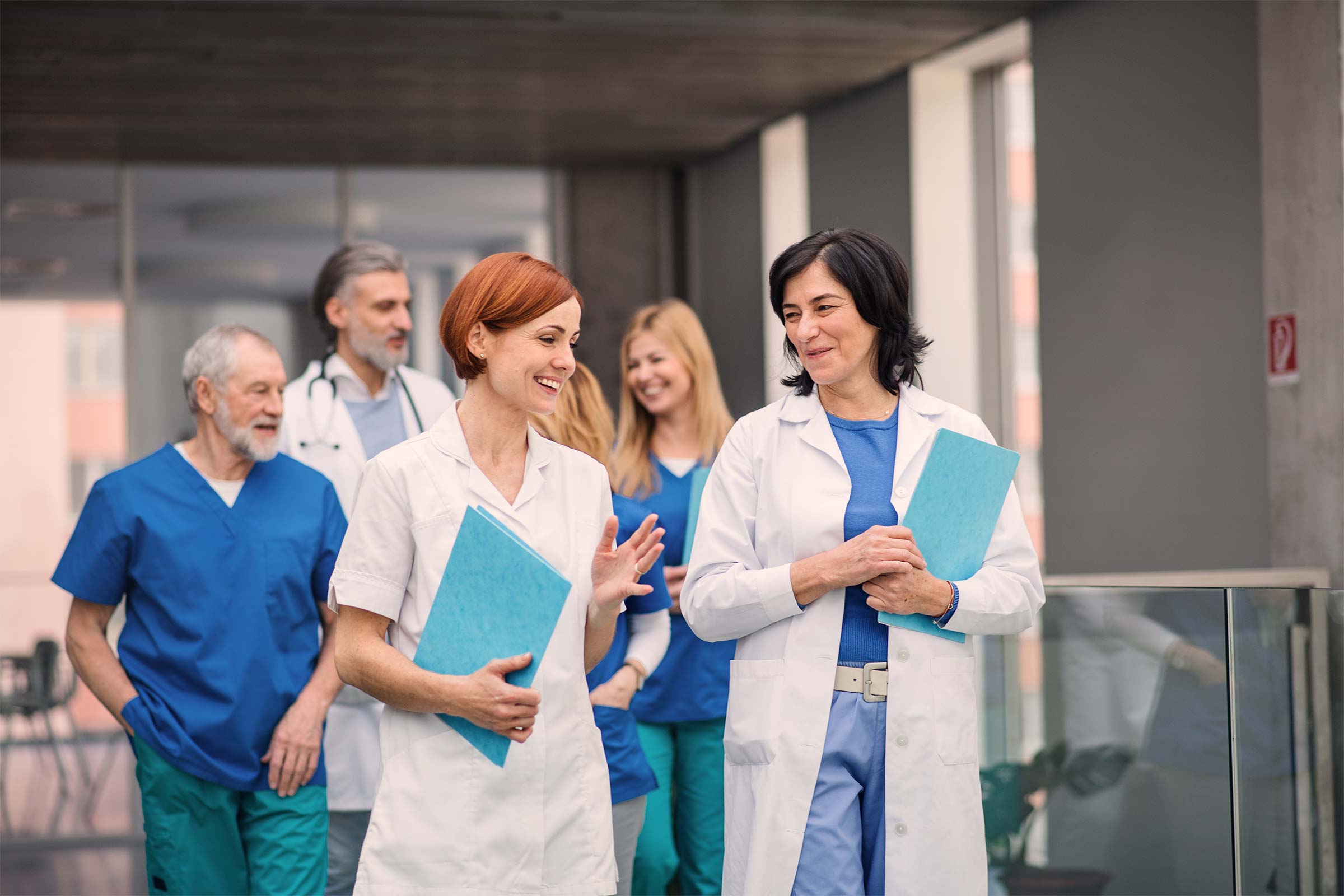 Physicians and clinical staff walking together in a medical corridor