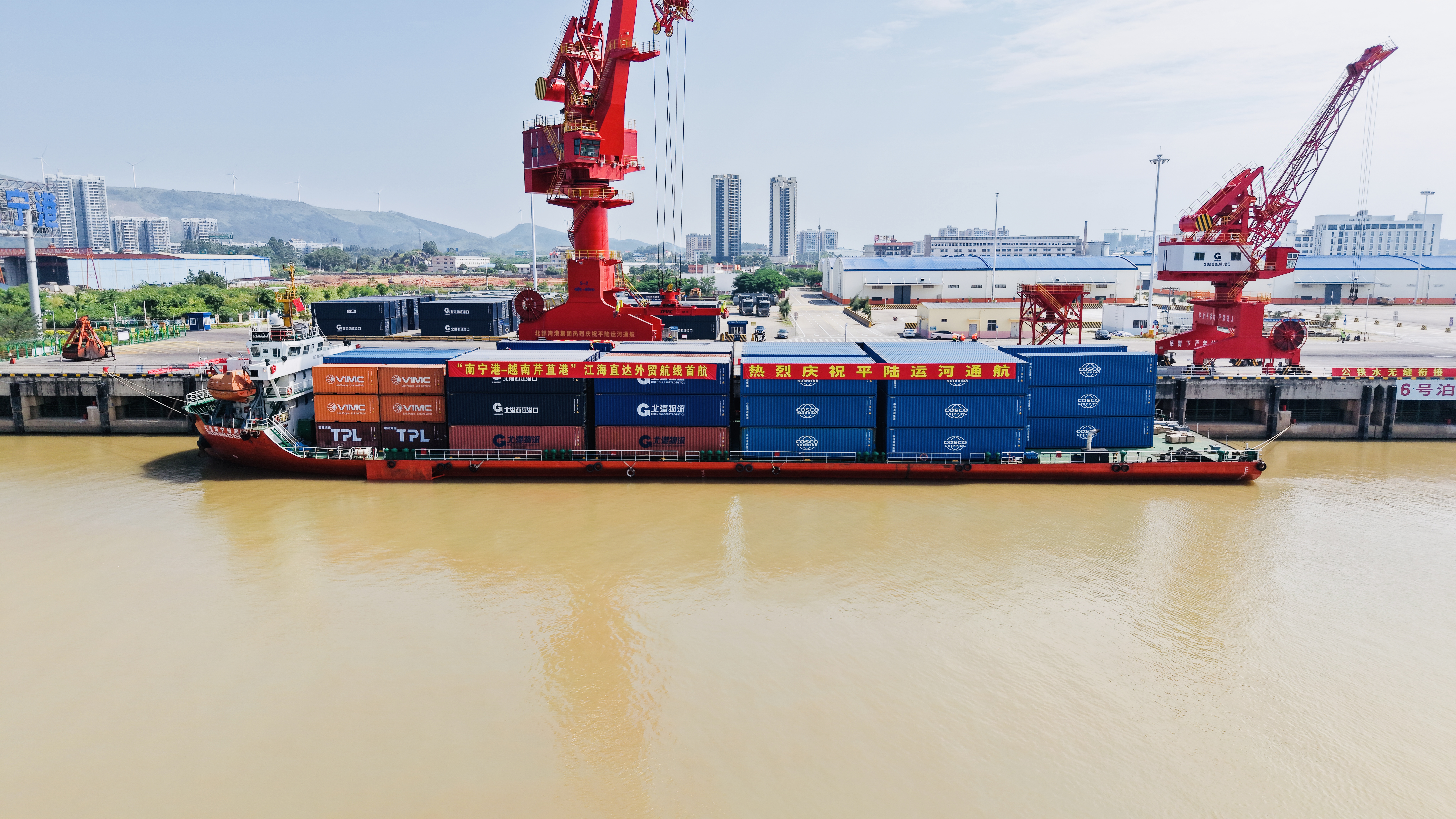 Container vessel alongside red port cranes in a photograph accompanying COSCO’s Pinglu Canal opening report