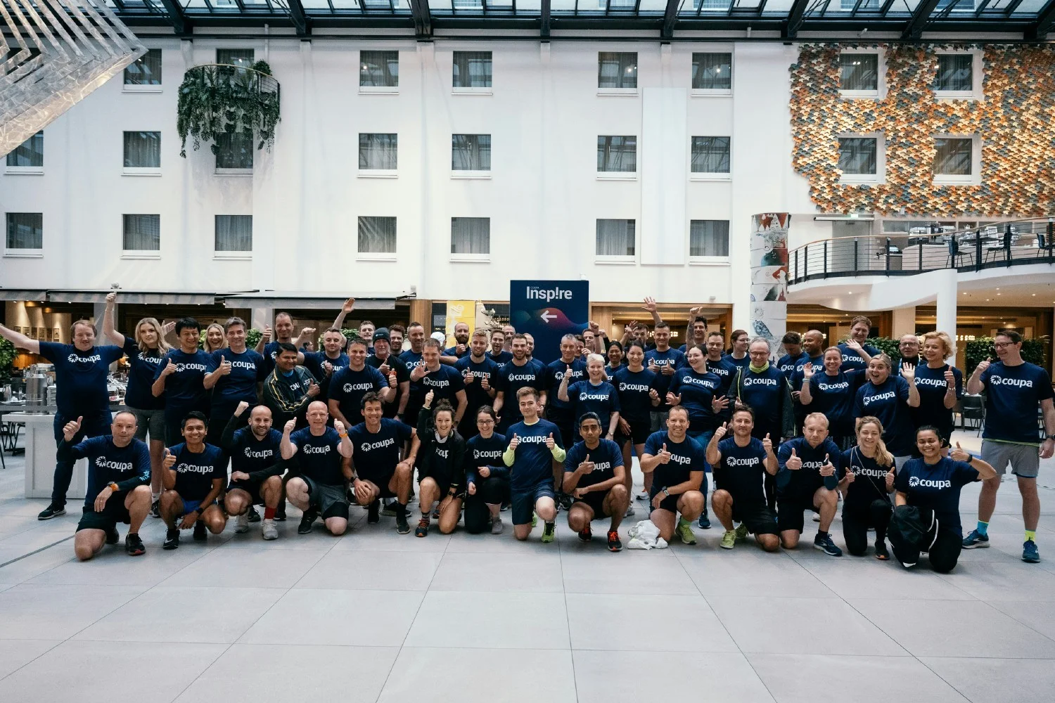 Large group of Coupa employees gathered in a bright atrium