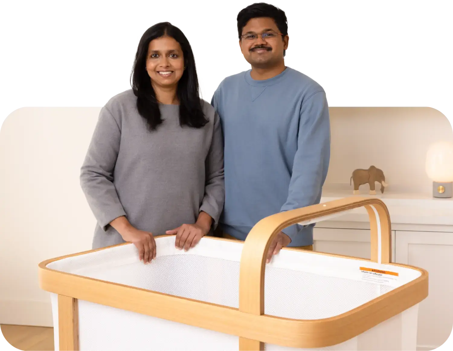Cradlewise founders Radhika and Bharath Patil standing behind their crib
