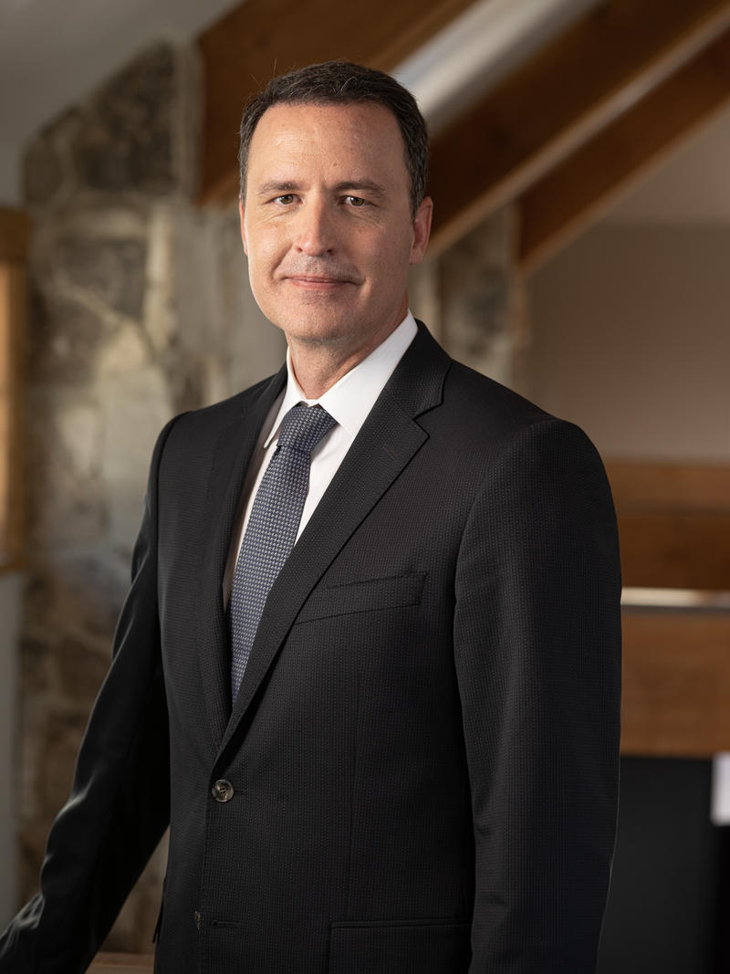 Craig Weston standing in a dark suit in an office setting