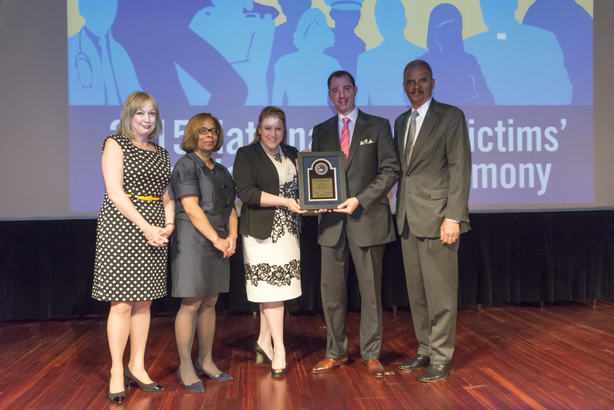 Kirsten Gappelberg and Crayton Webb holding Mary Kay’s 2015 Allied Professional Award alongside federal officials