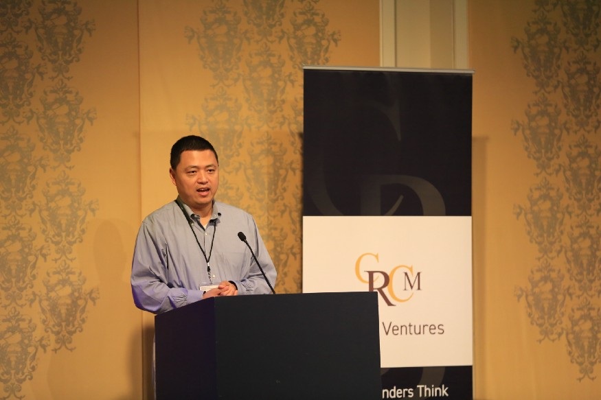 CRCM founder Chun Ding speaking at a podium beside CRCM Ventures signage
