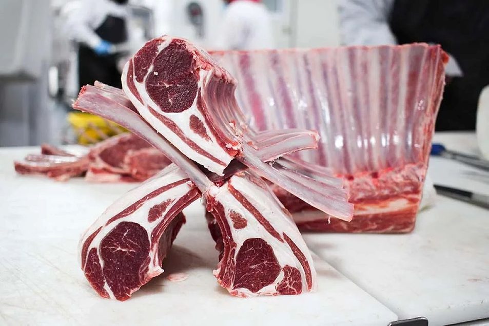 Precisely cut lamb chops arranged on a butcher block inside a Cream Co. facility