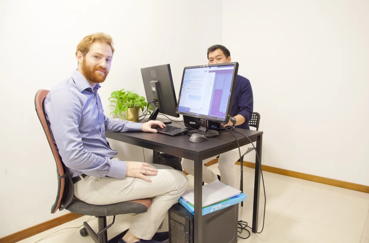 Guillaume Catella and a colleague working at a small table in Creatella’s early kitchen office