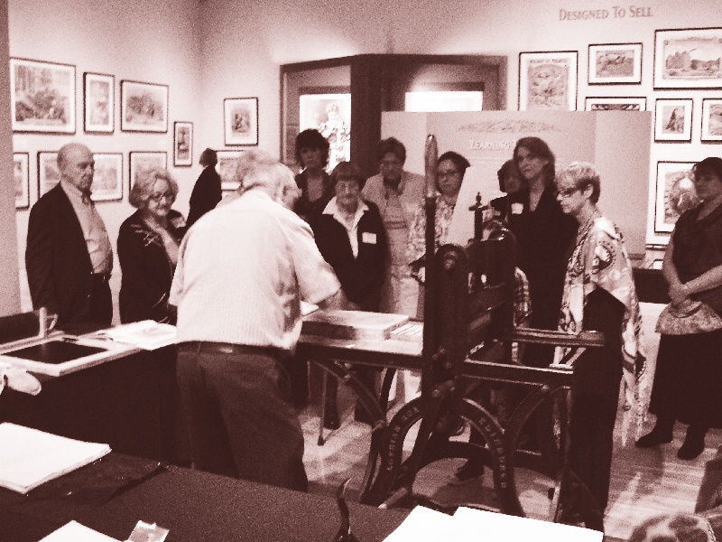 Visitors watch Tom Goglio demonstrate stone lithography at The Huntington exhibition.
