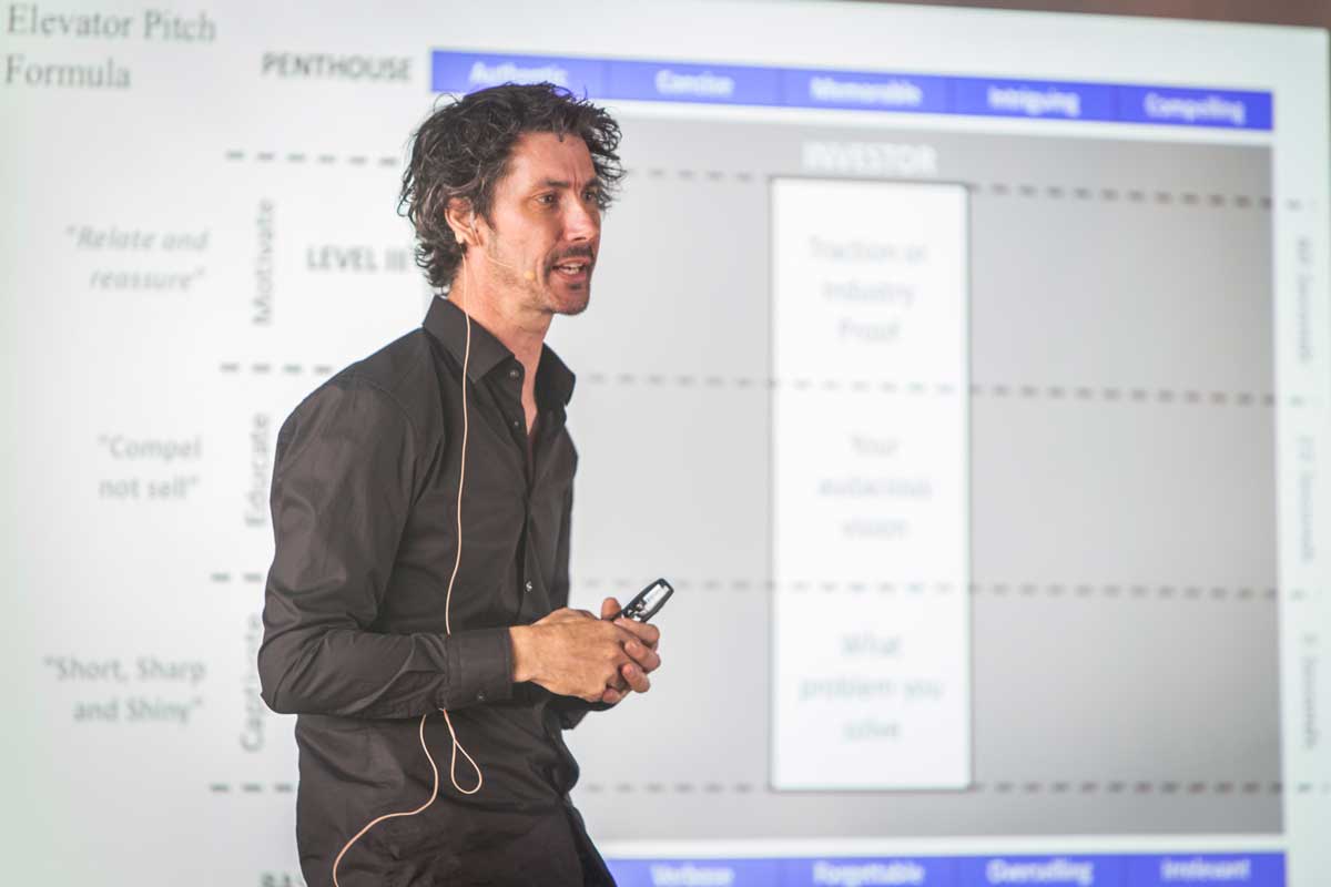 Creel Price presenting an entrepreneurship workshop in front of a projected business framework