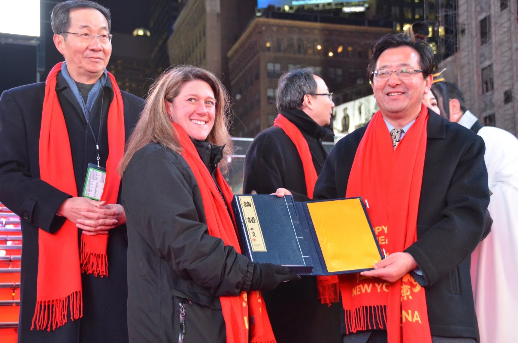 Cristin Burtis, center left, at an outdoor gathering with other participants wearing red scarves