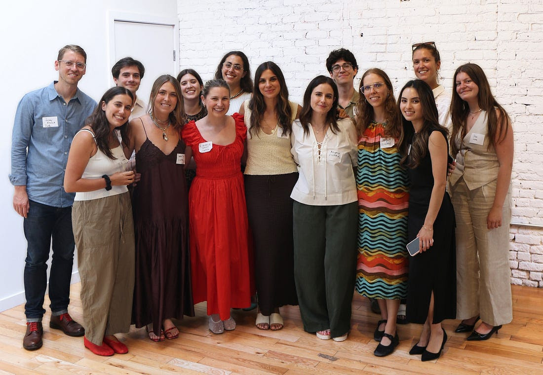 Cristina Suarez Krumsick, near the center, with a group at an Isetta gathering in a bright brick-walled space.