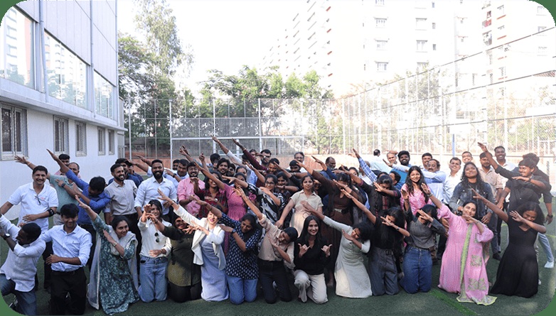 CRMIT team members posing together outdoors with their arms raised