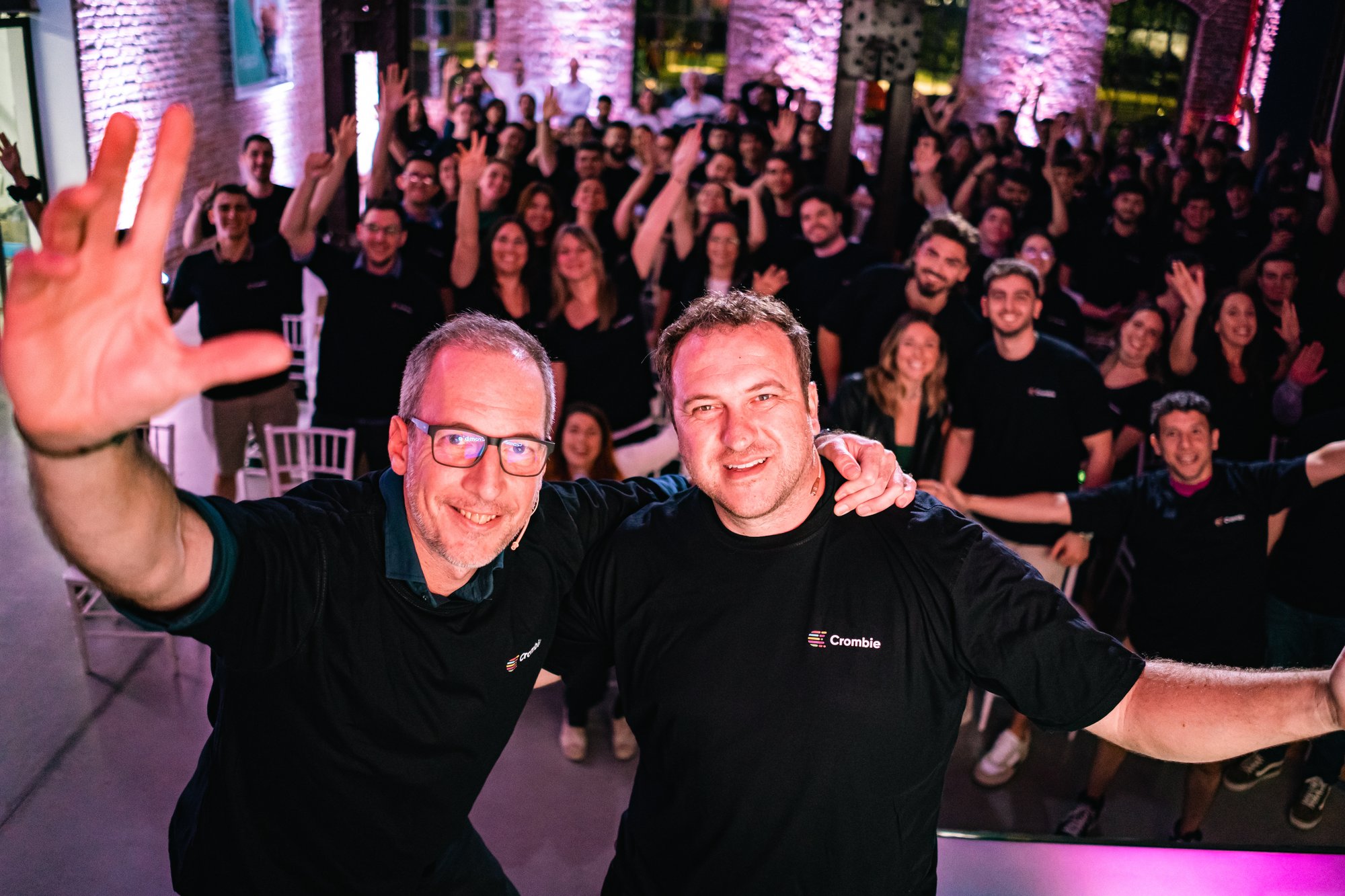 Crombie colleagues waving at a team gathering under purple lighting