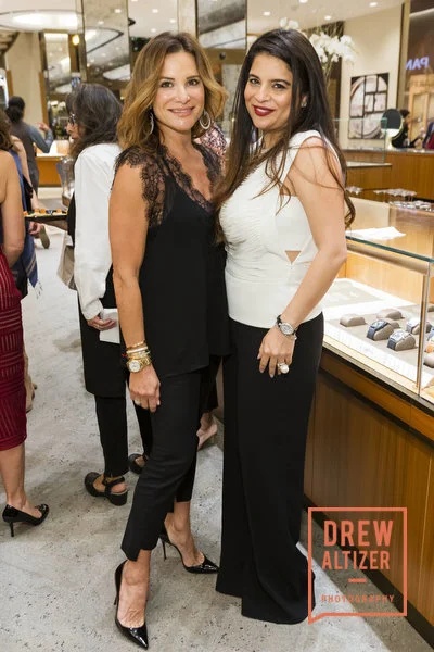 Two guests posing beside jewelry displays in an event photograph from Cross Marketing’s culture page