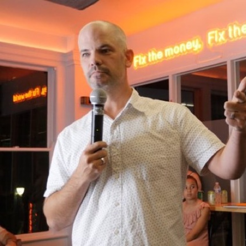 CrowdHealth founder Andy Schoonover holding a microphone