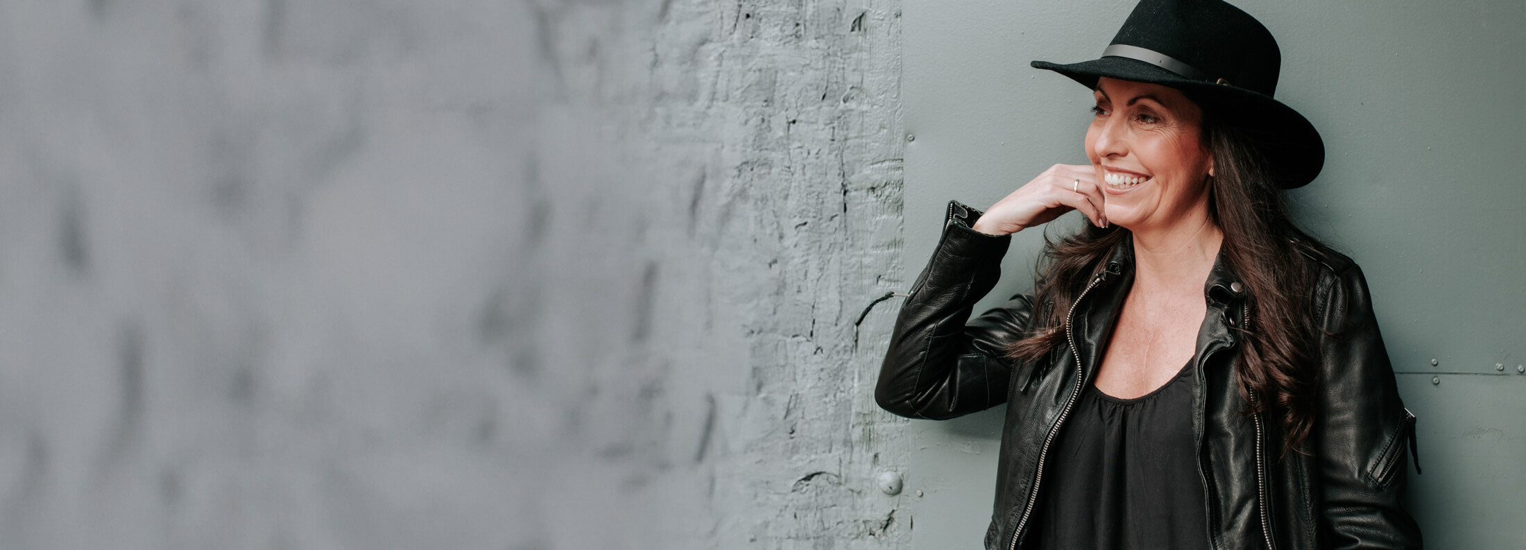 CRUSH founder and Creative Director Natalie Burkinshaw wearing a black hat and jacket