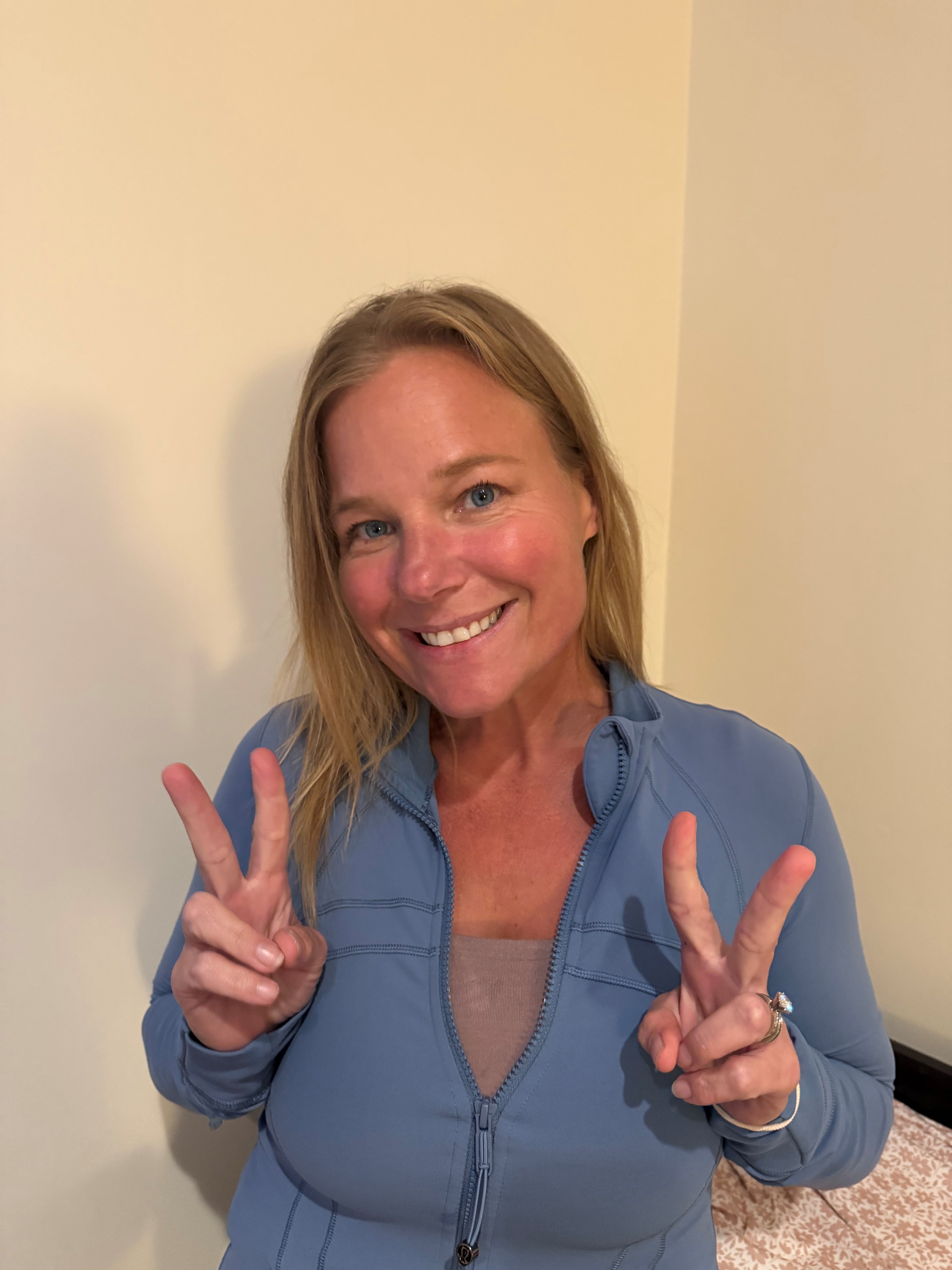 Julie Selders, Crystal Equation Vice President and COO, smiling and making peace signs