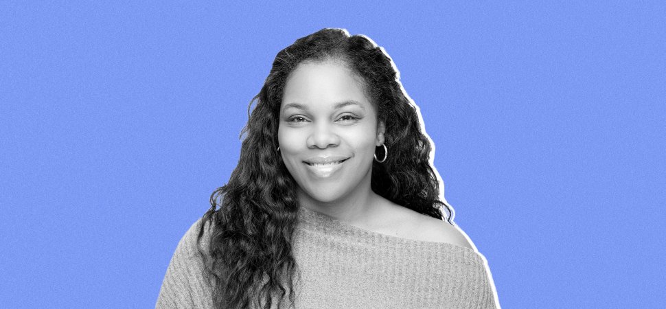 Crystal Etienne smiling against a blue background