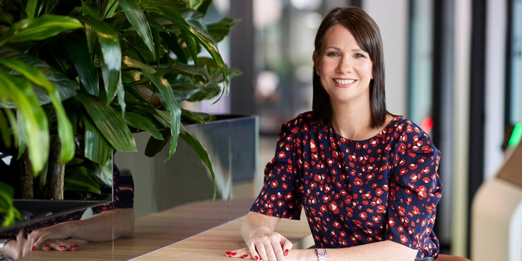 Caroline Rawlinson seated beside plants in an office