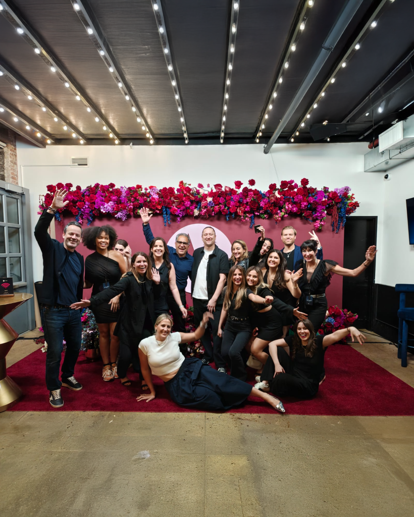 Current Global colleagues posing at a flower-filled event