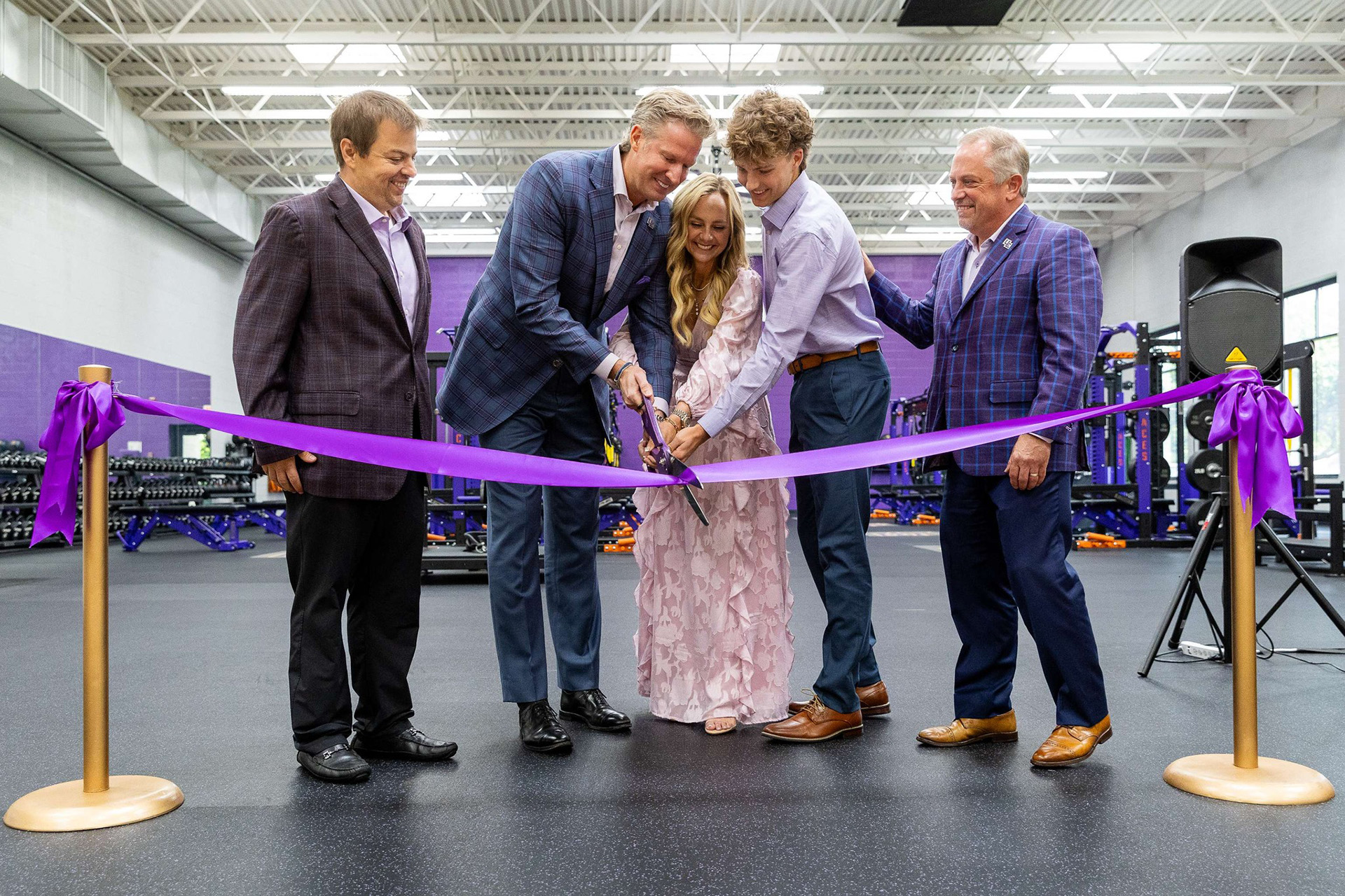The Begle family and University of Evansville leaders cutting a purple ribbon at the sports performance center